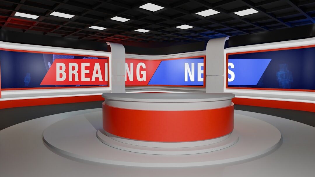 Modern TV newsroom studio with multiple screens and camera equipment